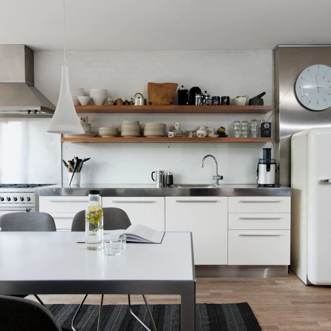 A kitchen with white cabinets and black chairs.